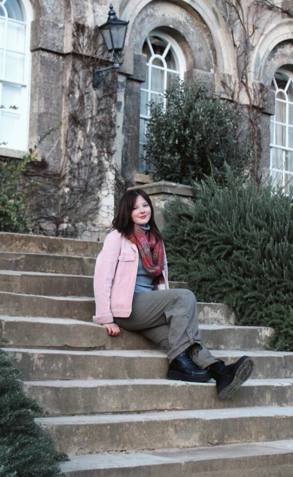 Zero Gravity member sitting on the steps of her uni